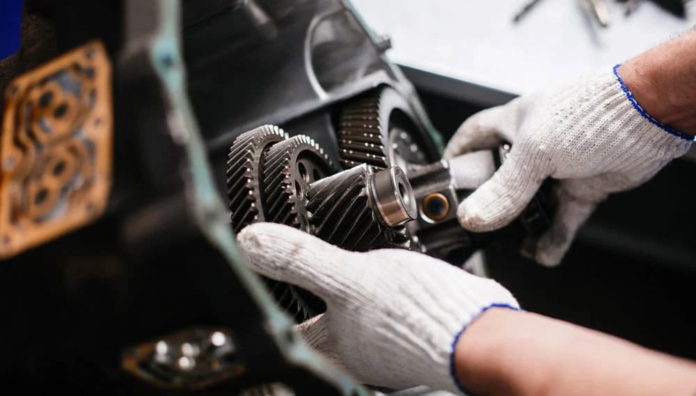 Technician assembling precision gearbox gears by hand
